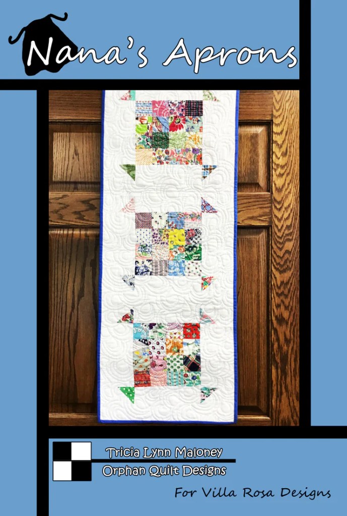 A quilted wall hanging titled 'Nana's Aprons' featuring three colorful apron designs made from various fabric squares, displayed against a blue background.