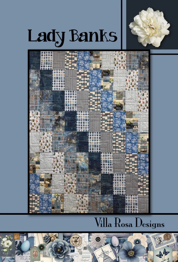 A quilt design titled 'Lady Banks' featuring a patchwork of various blue and grey fabrics, set against a light blue background. The quilt consists of squares and rectangles with floral and textured patterns. The design is framed by a dark border with the names 'Lady Banks' and 'Villa Rosa Designs' displayed prominently.