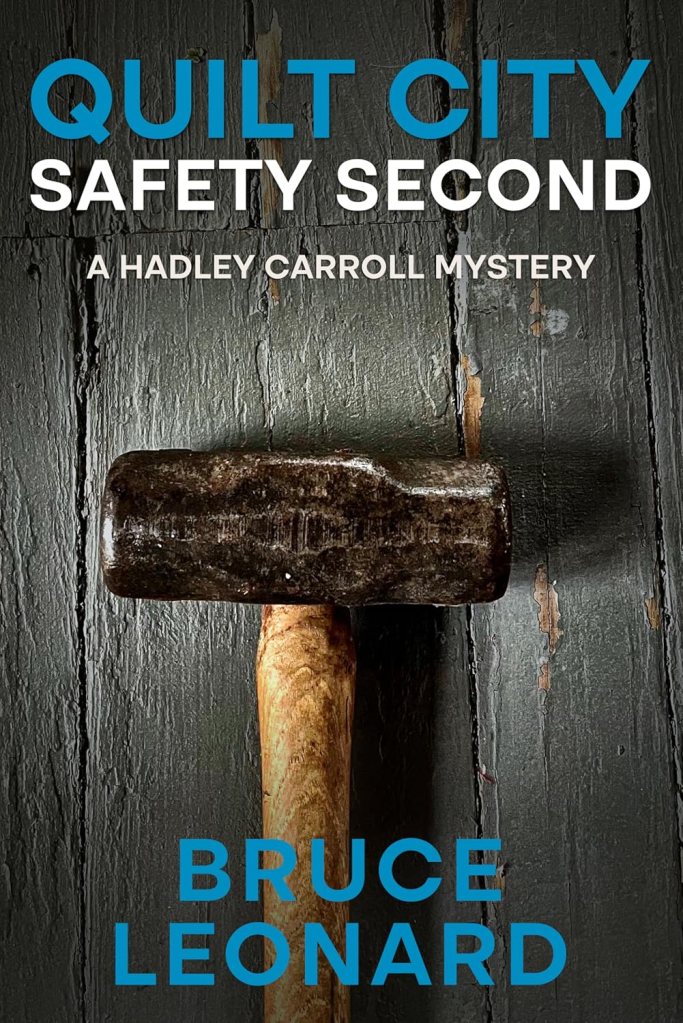 Cover of the book 'Quilt City: Safety Second' by Bruce Leonard, featuring a wooden mallet against a textured gray background.