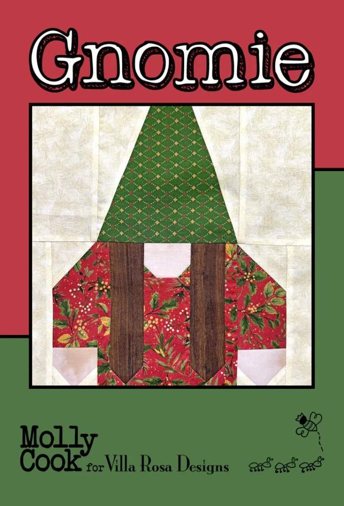 A quilt pattern featuring a whimsical gnome design with a green hat and red outfit, designed by Molly Cook for Villa Rosa Designs.