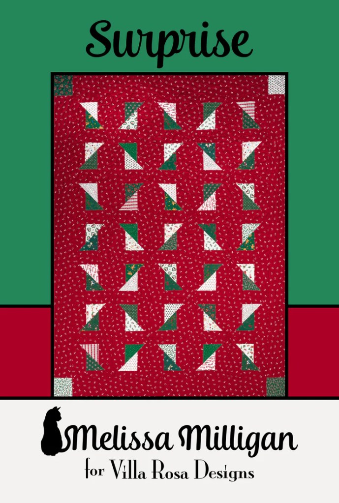 Quilt titled 'Surprise' featuring a pattern of red, green, and white fabrics, designed by Melissa Milligan for Villa Rosa Designs.