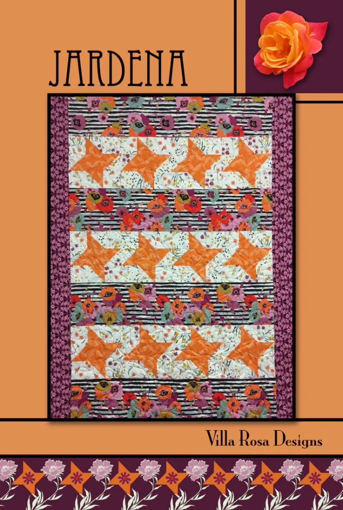 Colorful quilt design featuring orange stars and floral patterns, titled 'Jardena', by Villa Rosa Designs.