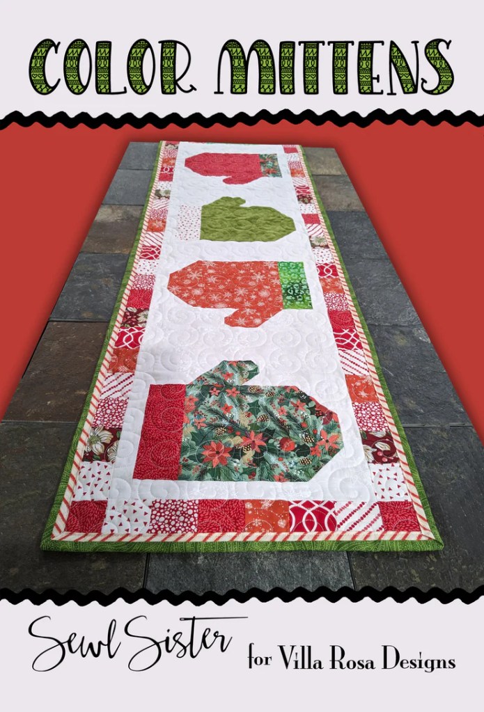 A quilted table runner featuring colorful mitten shapes in red, green, and patterned fabrics, titled 'Color Mittens' with a festive design.