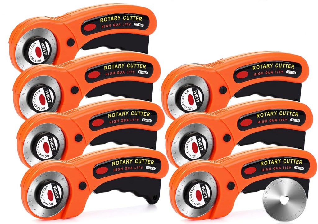 A collection of rotary cutters with orange handles and black accents, arranged in a row on a white background.
