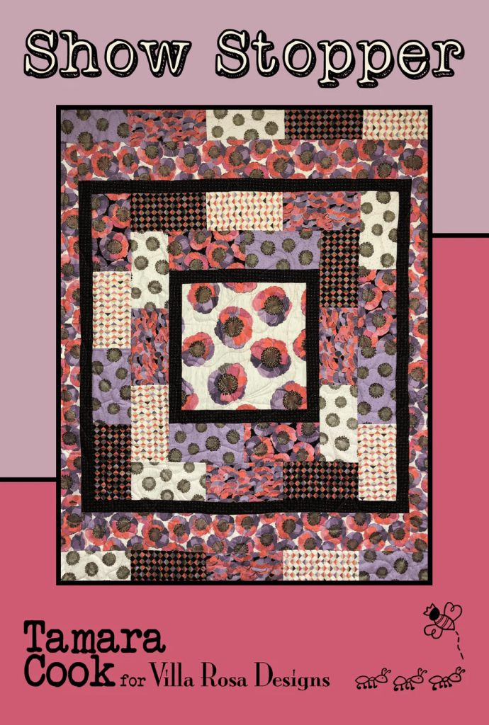 A vibrant quilt design titled 'Show Stopper' by Tamara Cook for Villa Rosa Designs, featuring a layered pattern with floral and geometric prints in shades of purple, red, and black.