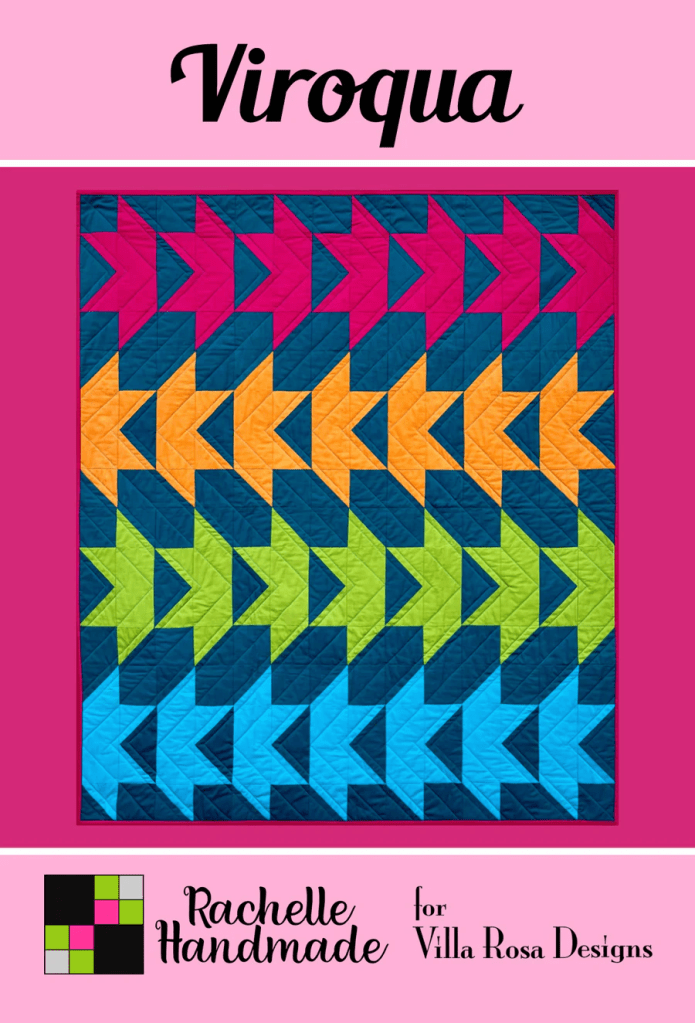 A colorful quilt design named 'Viroqua' featuring an arrow pattern in shades of orange, pink, blue, green, and teal against a pink background. The quilt is attributed to Rachelle Handmade for Villa Rosa Designs.
