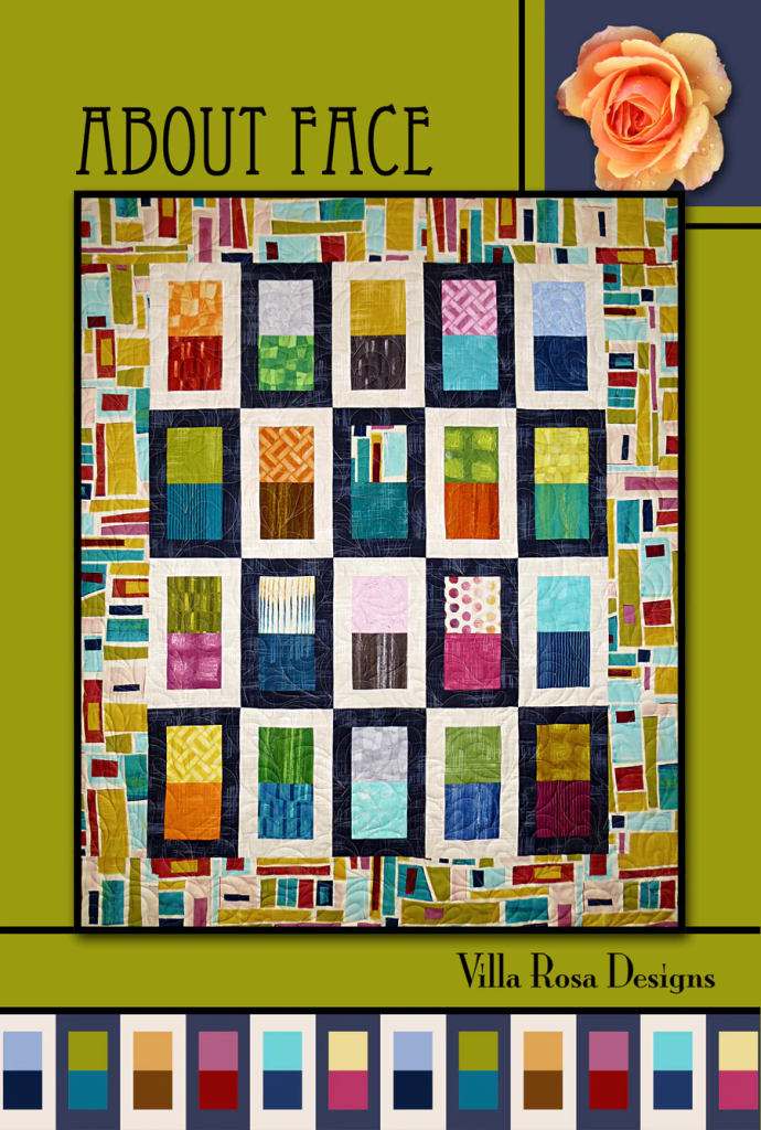 Colorful quilt design titled 'About Face' by Villa Rosa Designs featuring a pattern of squares and rectangles in various colors and textures on a framed background.