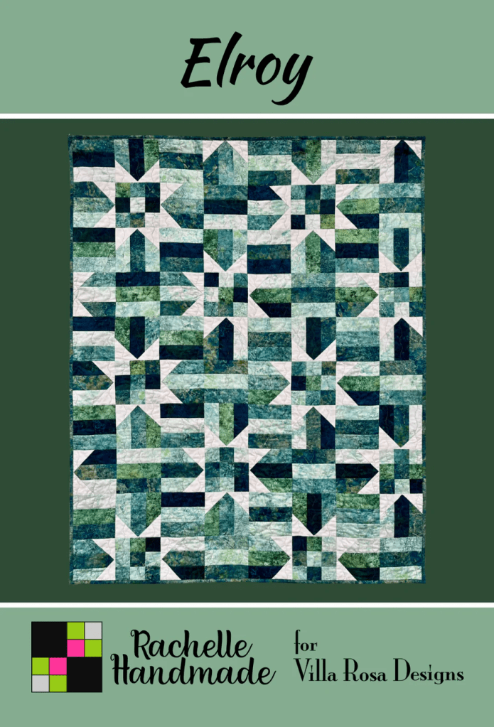 A patterned quilt named 'Elroy' featuring a mix of blue, green, and white geometric shapes, designed by Rachelle Handmade for Villa Rosa Designs.