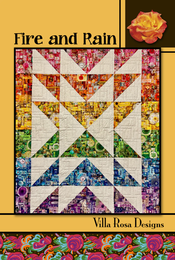 A colorful quilt titled 'Fire and Rain' by Villa Rosa Designs, featuring a star pattern with vibrant fabric squares in shades of pink, orange, green, blue, and purple against a textured white background.