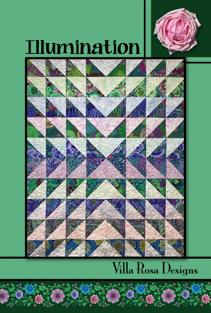 A colorful quilt featuring a pattern of triangles in shades of green, blue, purple, and pink, titled 'Illumination' by Villa Rosa Designs, set against a green background with a floral border.