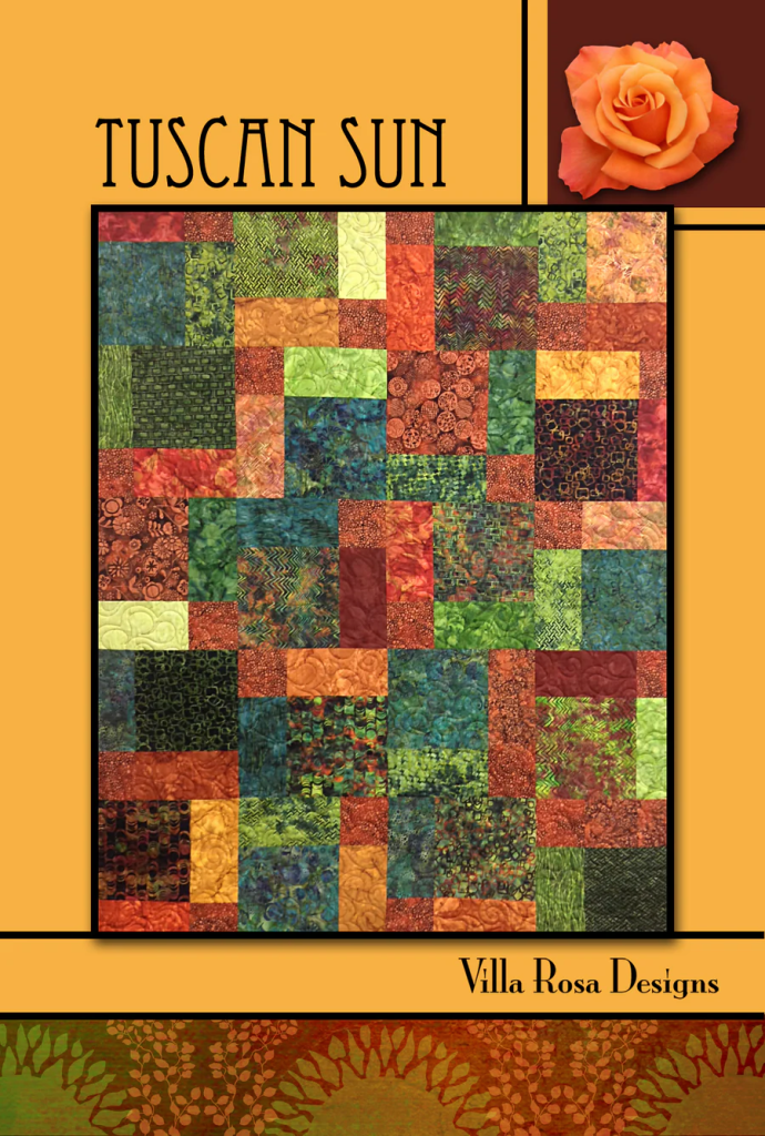 A colorful quilt design titled 'Tuscan Sun' featuring a patchwork of various textures and patterns in shades of green, orange, brown, and red. The design includes a rose graphic and is credited to Villa Rosa Designs.