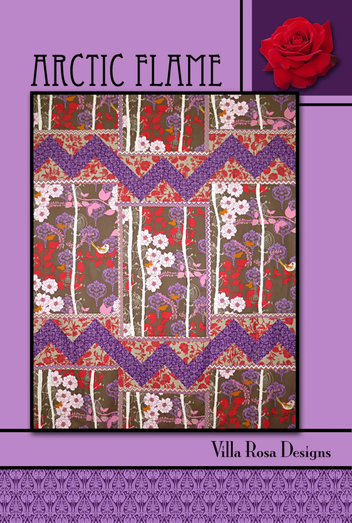 A decorative quilt pattern titled 'Arctic Flame' by Villa Rosa Designs, featuring vibrant floral designs in red, pink, and purple, with a zigzag pattern on a brown background.