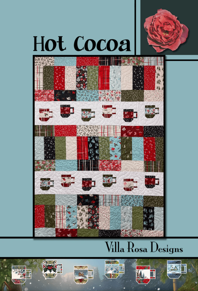A colorful quilt design titled 'Hot Cocoa' featuring various patterns in red, green, blue, and white, with illustrated cups of hot cocoa throughout. The quilt is bordered with a decorative floral design and includes branding for Villa Rosa Designs.