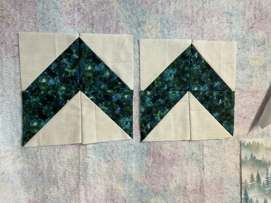 Two quilt blocks featuring a geometric design with green and blue fabric on a light background.