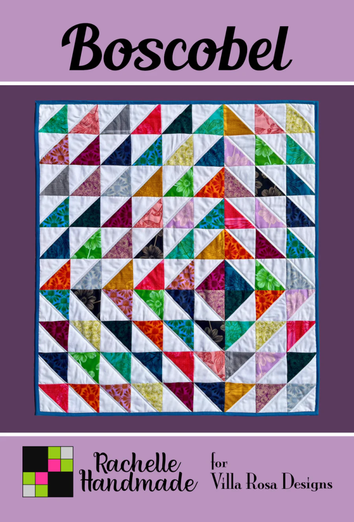 A colorful quilt featuring a geometric pattern of triangles in various colors and textures, titled 'Boscobel', designed by Rachelle Handmade for Villa Rosa Designs.