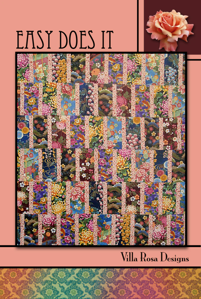 A vibrant quilt design featuring floral patterns in various colors, titled 'Easy Does It' by Villa Rosa Designs. The background is a blend of soft pink and intricate designs, with the title and brand name displayed prominently.