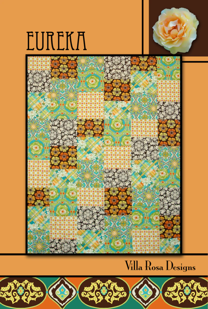 A colorful quilt design featuring various patterned squares in vibrant colors, with an orange background and a rose graphic in the top right corner. Text includes 'Eureka' and 'Villa Rosa Designs'.