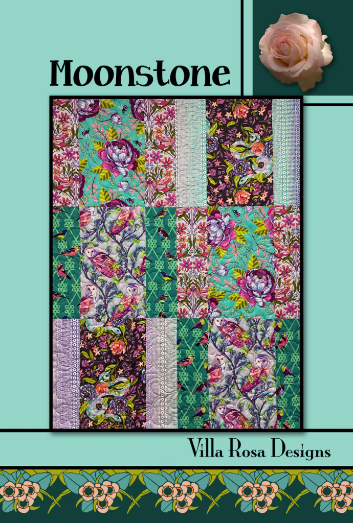 Colorful quilt design titled 'Moonstone' featuring various floral and animal patterns in shades of blue, purple, and green, with branding from Villa Rosa Designs.
