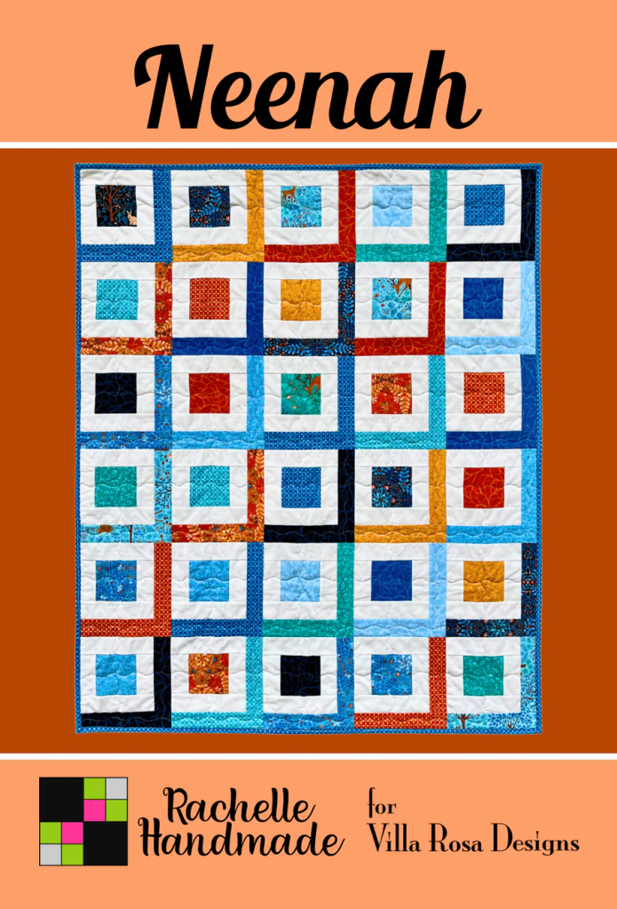 Colorful quilt featuring a geometric design with squares and contrasting colors, labeled 'Neenah' by Rachelle Handmade for Villa Rosa Designs.