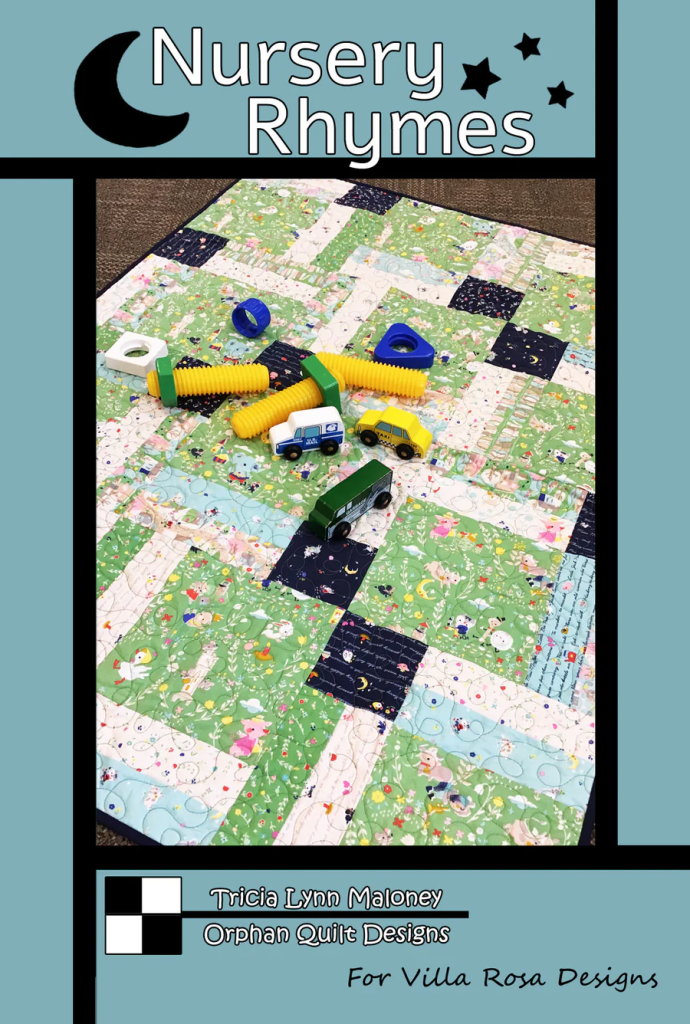 A colorful nursery rhyme-themed quilt with various patches featuring playful illustrations, surrounded by colorful toys including yellow construction tubes and small vehicles.