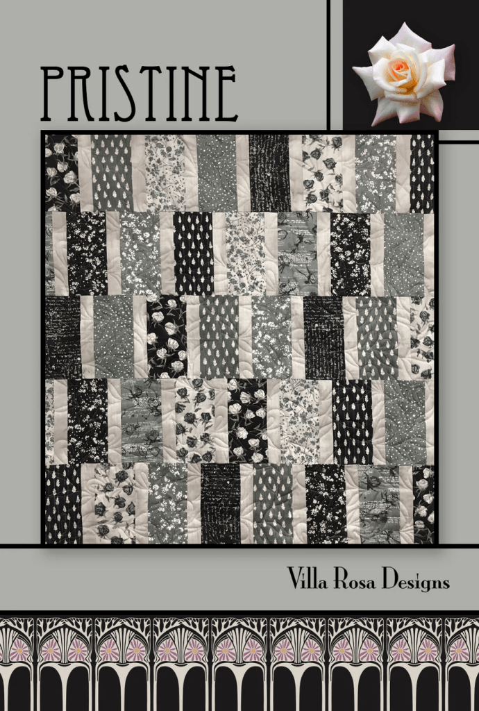 A quilt titled 'Pristine' designed by Villa Rosa Designs, featuring a patchwork of gray and black fabrics with floral and patterned designs, complemented by a decorative rose in the upper right corner.