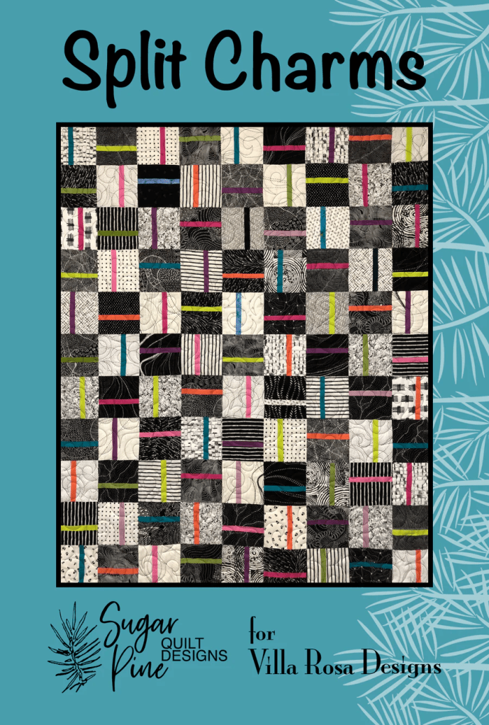 A colorful quilt titled 'Split Charms' featuring a pattern of squares in black, white, and vibrant colors, designed by Sugar Pine for Villa Rosa Designs.