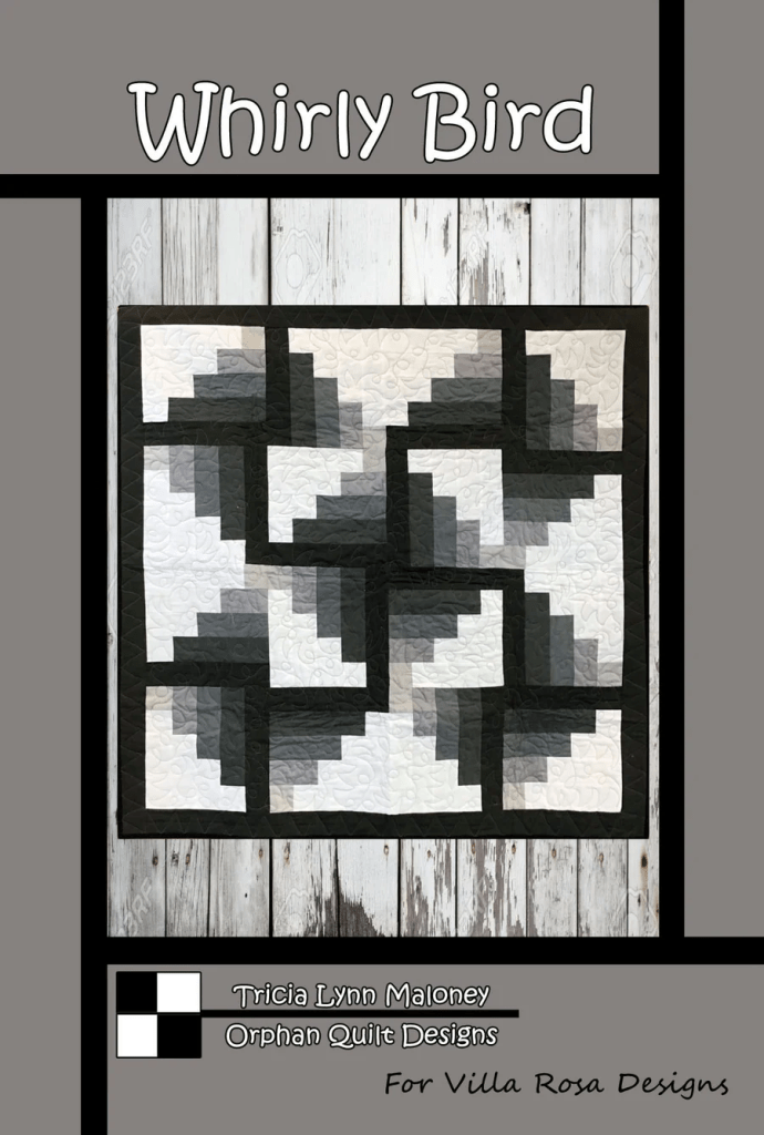 A quilt design titled 'Whirly Bird' featuring geometric patterns in shades of gray and white on a wooden backdrop. The design is framed with black borders and includes text noting the designer, Tricia Lynn Maloney, and the brand, Orphan Quilt Designs for Villa Rosa Designs.