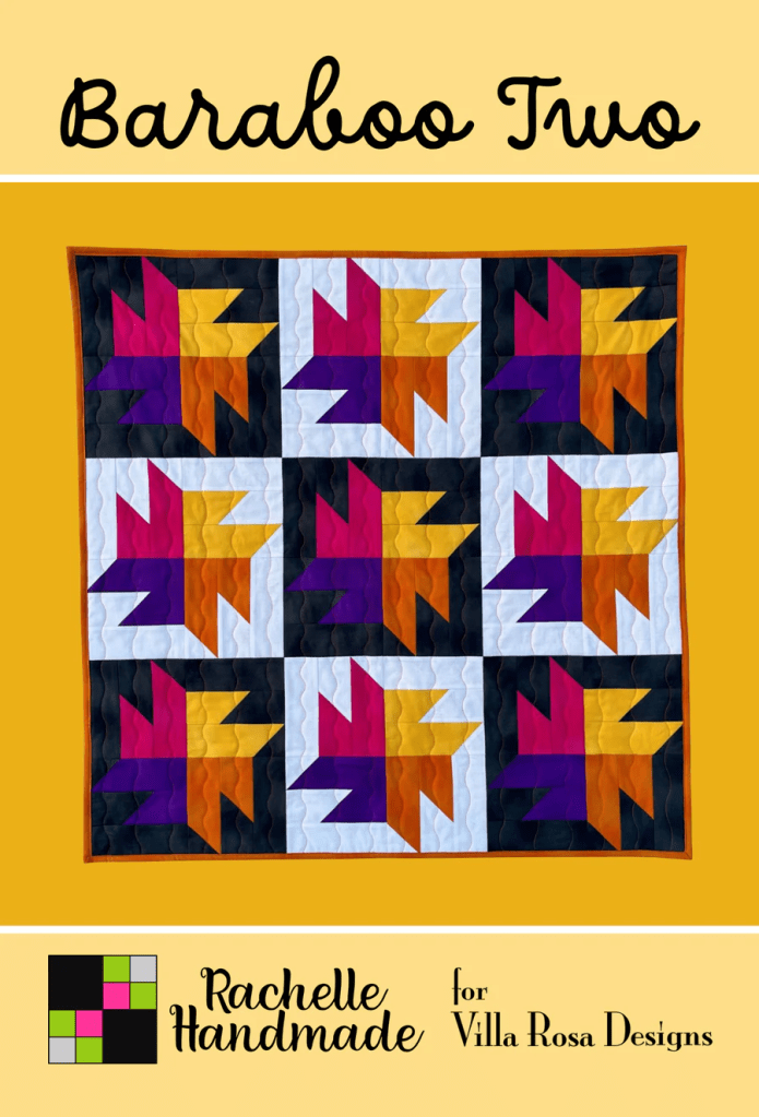 A quilt featuring a colorful block pattern with shades of orange, purple, black, and white, titled 'Baraboo Two' by Rachelle Handmade for Villa Rosa Designs.