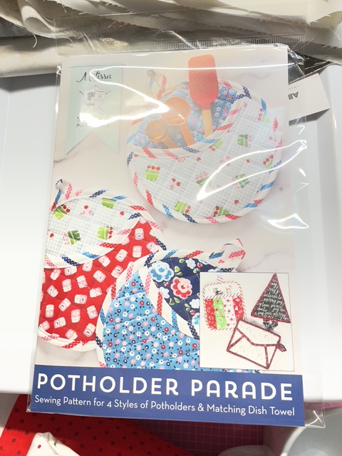 Sewing pattern for Potholder Parade featuring colorful potholders and a matching dish towel.